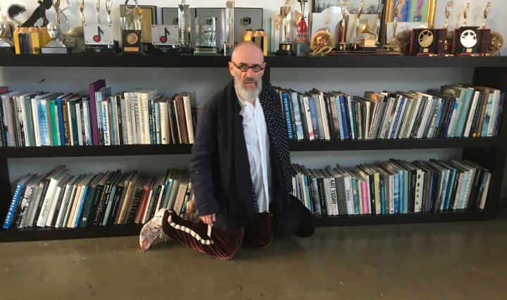 Director Tony Kaye beside a shelf of film awards and books