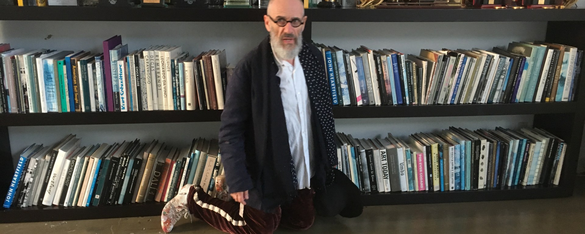 Director Tony Kaye beside a shelf of film awards and books